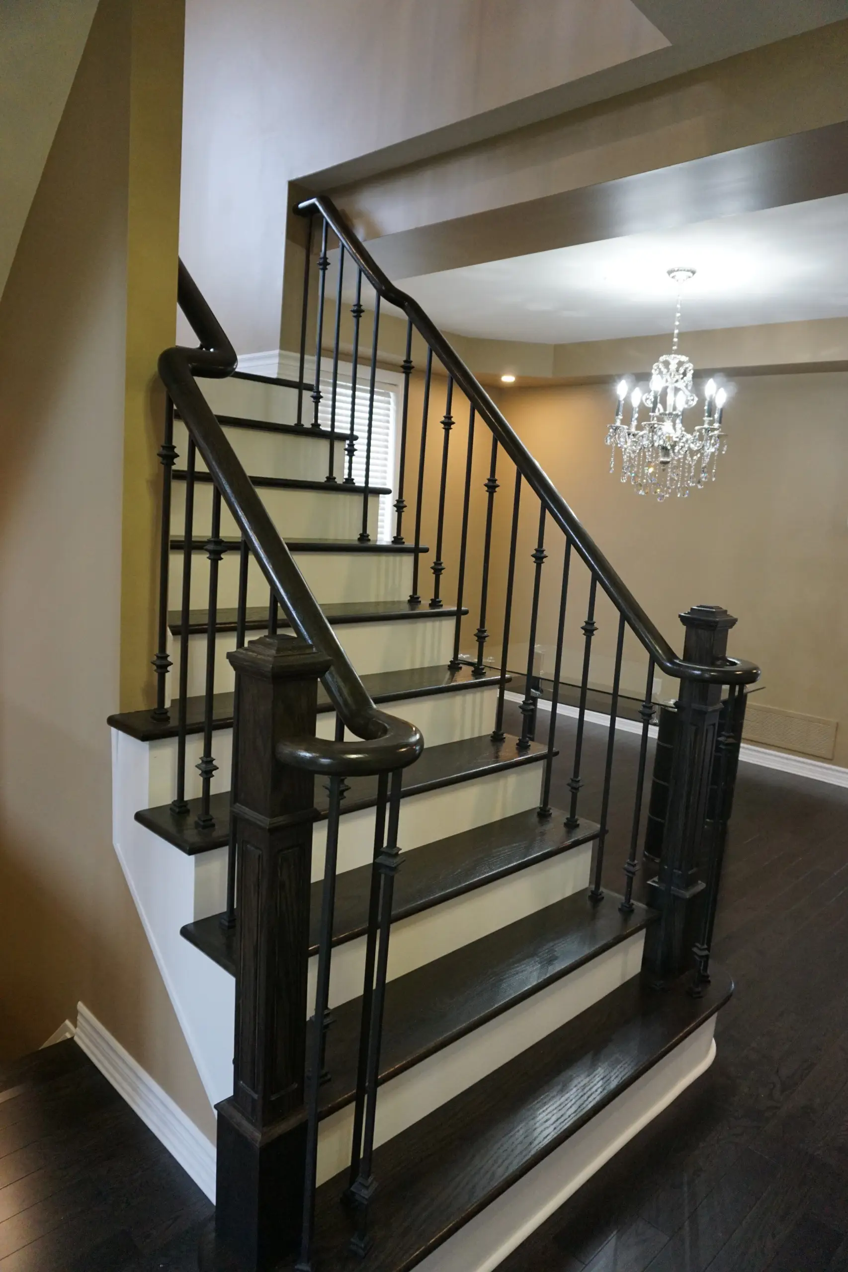 Curved staircase featuring premium hardwood treads and vertical iron balusters for a refined modern look.