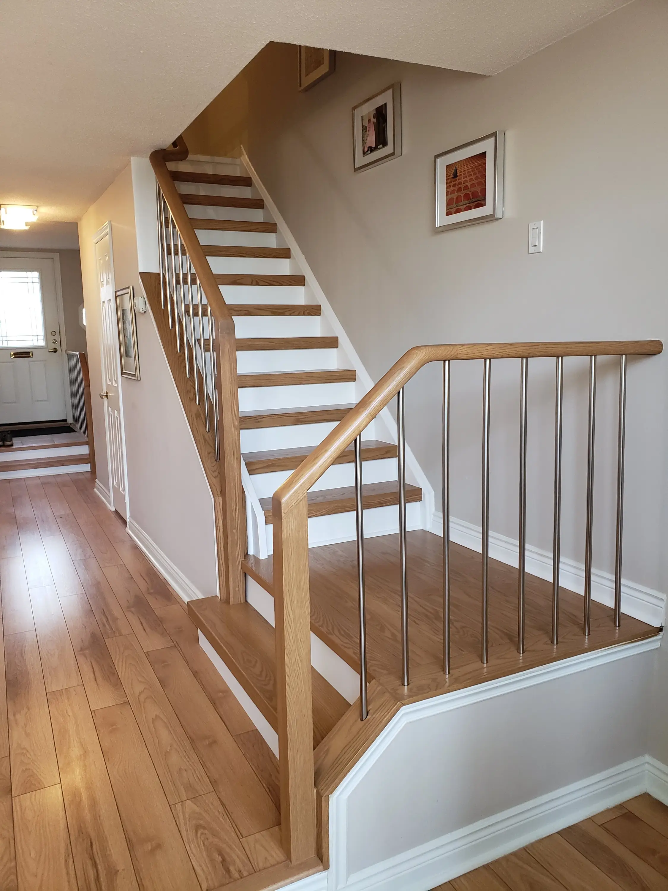 Minimalist staircase with pale hardwood treads and slim metal balusters, perfect for modern interior design.
