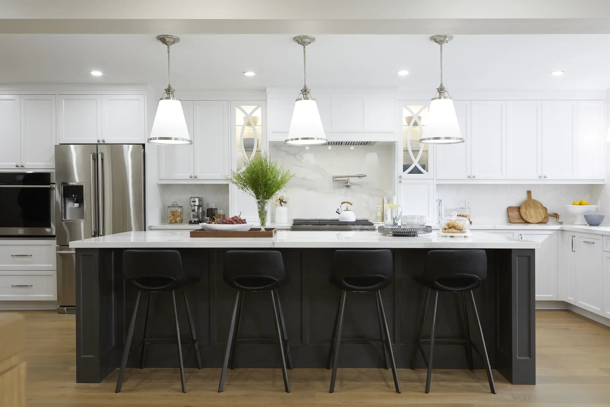A large renovated kitchen showcasing a generous countertop with ample workspace and seating, alongside a cozy dining table for gatherings.