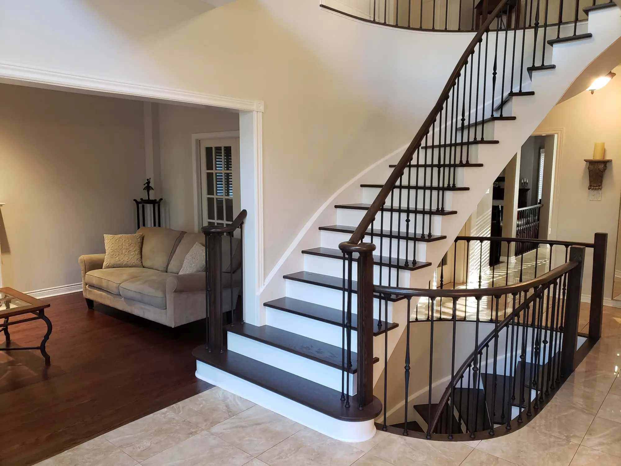 Hardwood staircase renovation in Toronto with iron railing.